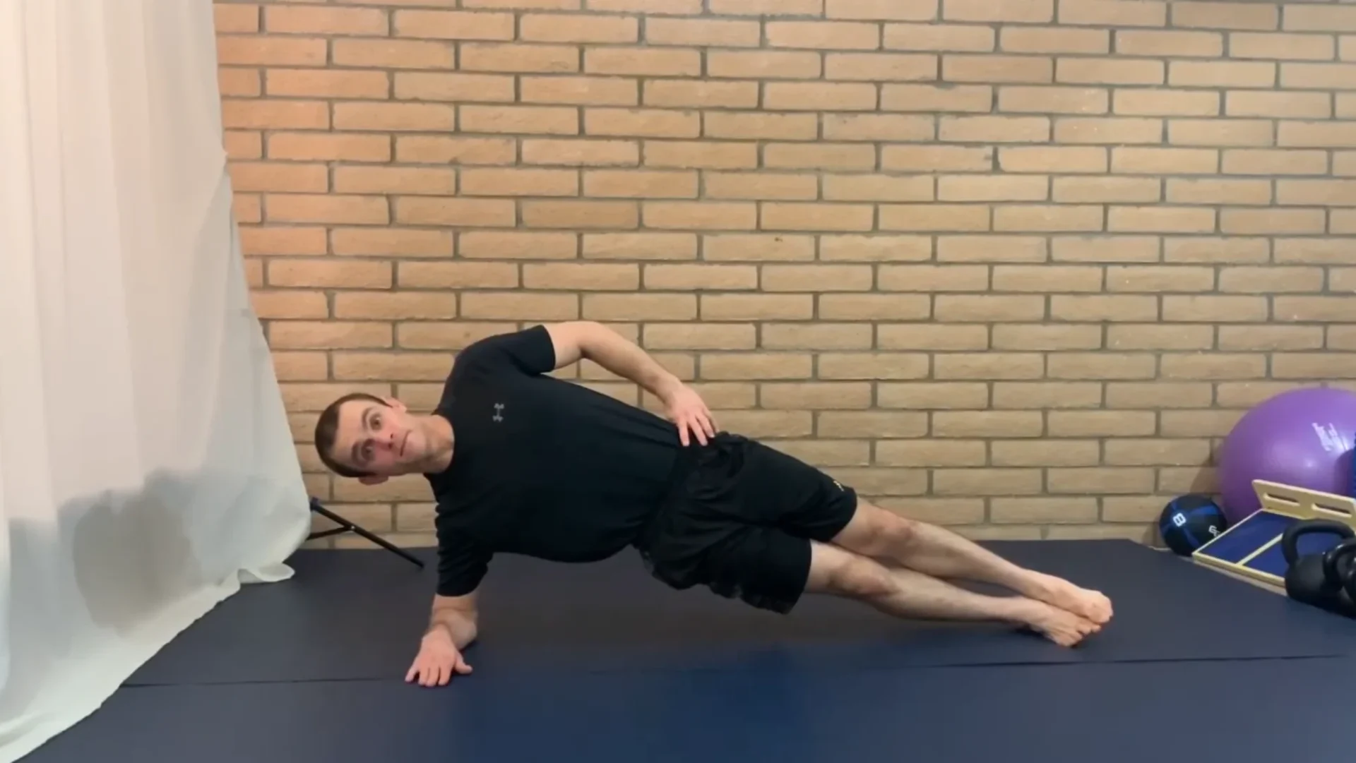jordan fernandez demonstrates the elbow side plank exercise