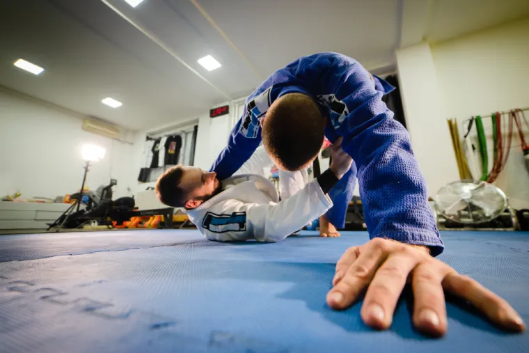 BJJ workout training for stability. Two men grappling in Brazilian Jiu-Jitsu gis.