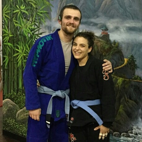 Jordan Fernandez earns his BJJ blue belt - Jordan posing with Brittney both wearing jiu jitsu blue belts, showcasing how long to blue belt in bjj